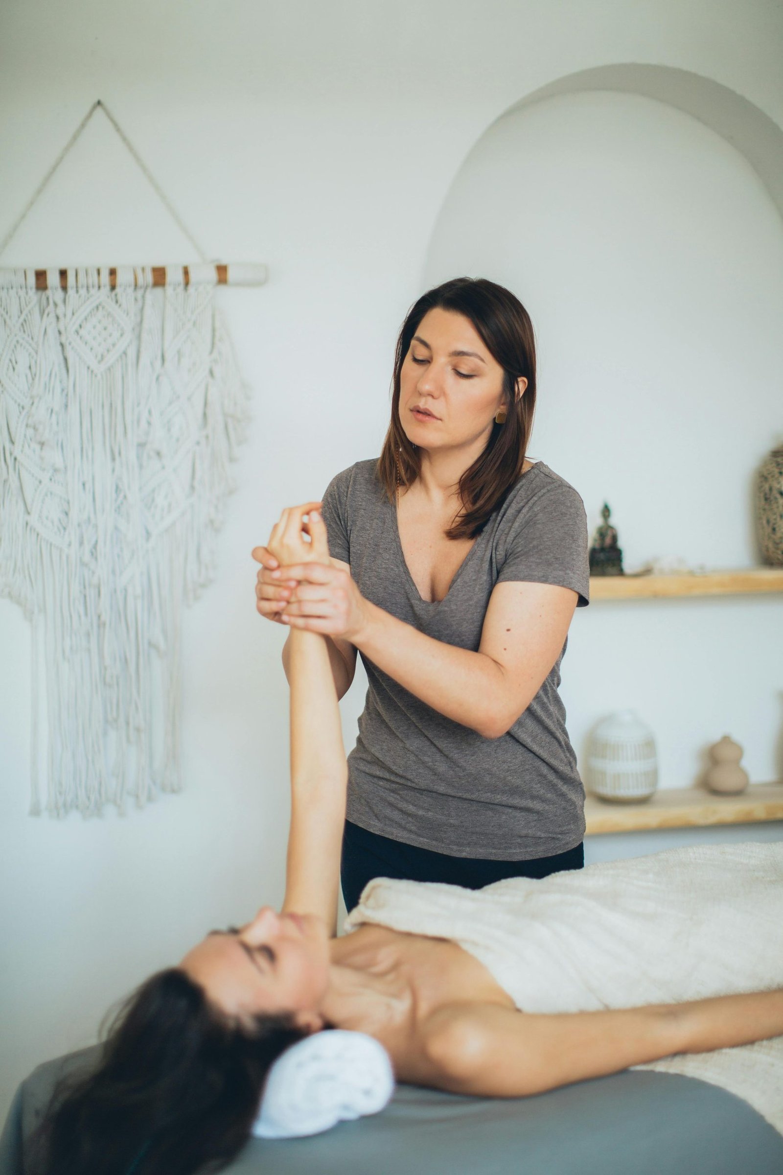 A Woman in Gray Shirt Massaging a Woman's Hand